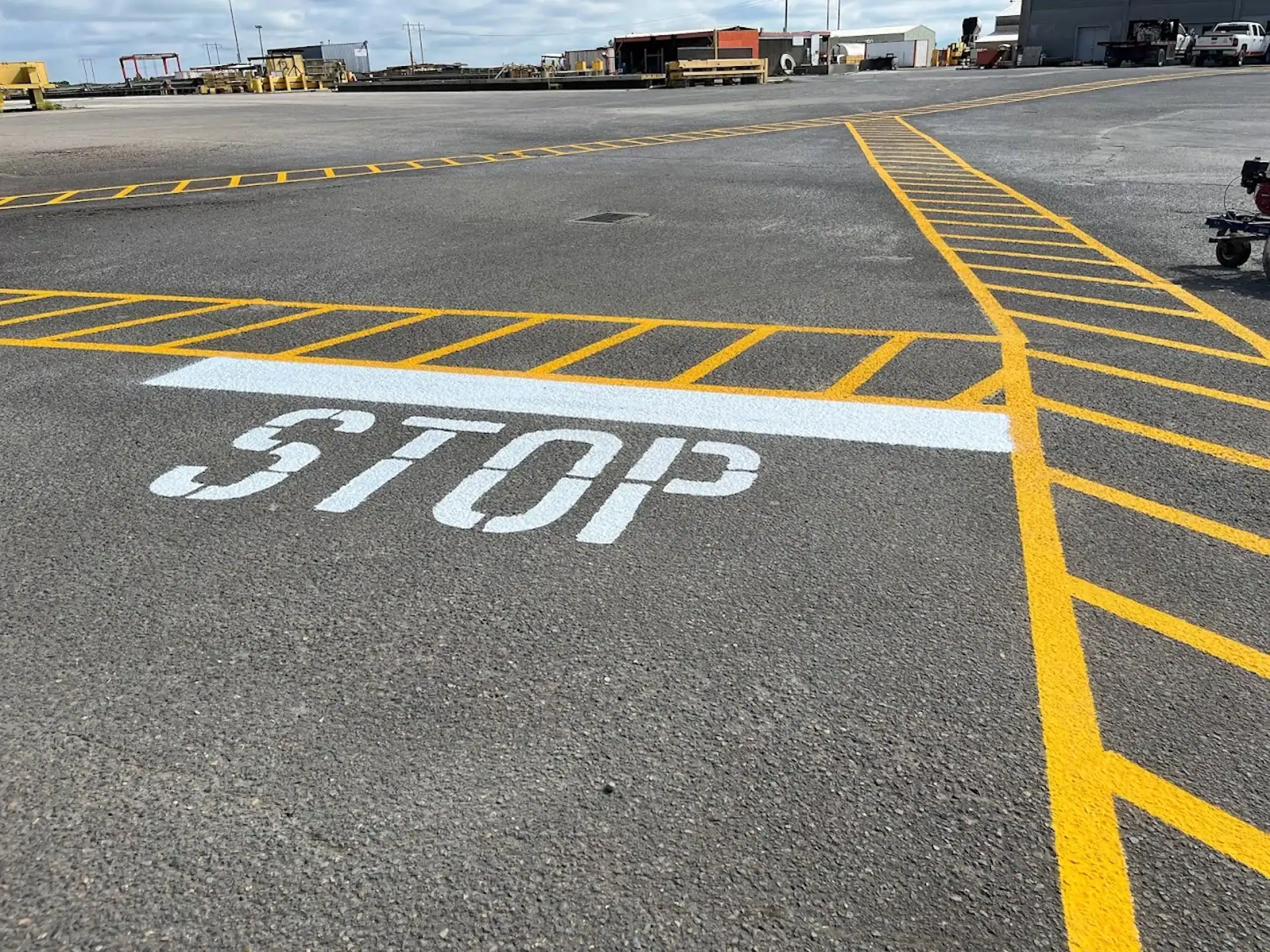 Asphalt Parking lot with yellow caution stripes and Stop line